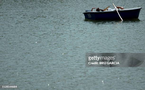 Couple take a sun bath in a boat in the El Retiro's Park lake on a hot summer day, Madrid 14 July 2005.