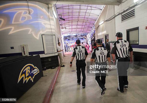 Side judge Jimmy DeBell , line judge Jeff Seeman , and umpire Bill Schuster take to the field before their first game back after a lockout. They're...