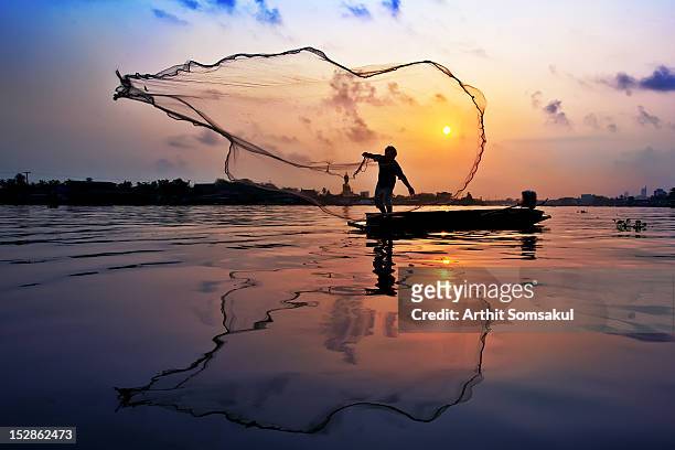 fisherman at chaophaya river - rete da pesca commerciale foto e immagini stock