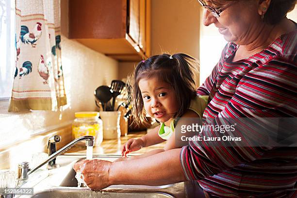 woman washes toddler hands at kitchen sink - midsection 個照片及圖片檔
