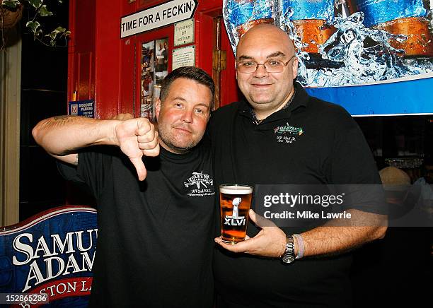 Musician Ken Casey of Dropkick Murphys poses with Foley's owner Shaun Clancy as Casey guest bartends as part of a Super Bowl XLVI wager at Foley's NY...