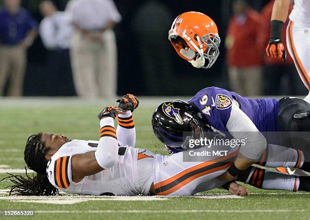 Cleveland Browns wide receiver Josh Cribbs is separated from his helmet and the ball by Baltimore Ravens long snapper Morgan Cox resulting in a...