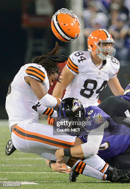 Cleveland Browns wide receiver Josh Cribbs is separated from his helmet and the ball by Baltimore Ravens long snapper Morgan Cox resulting in a...