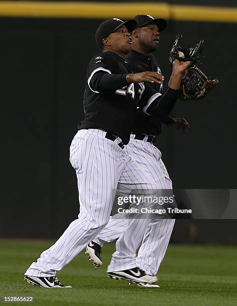 Chicago White Sox left fielder Dayan Viciedo, left, and center fielder Alejandro DeAza almost collide as Viciedo makes the catch on Desmond Jenning's...