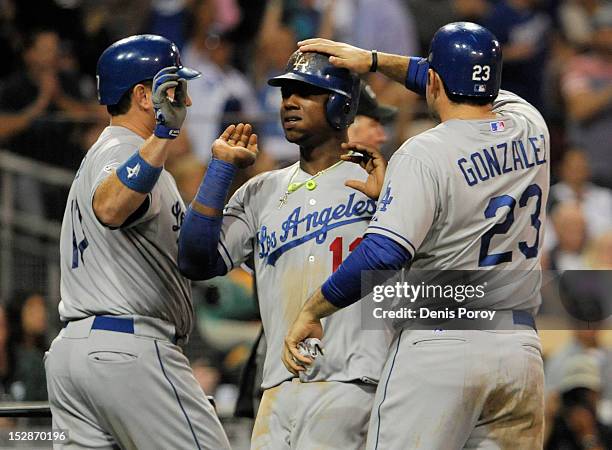 Ellis of the Los Angeles Dodgers and Adrian Gonzalez congratulate Hanley Ramirez as he scores during the fifth inning of a baseball game against the...