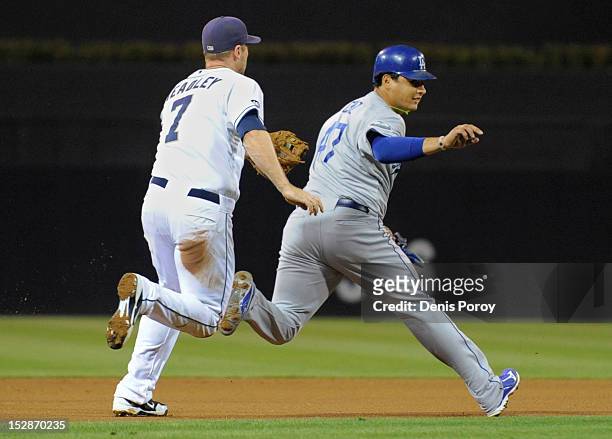 Chase Headley of the San Diego Padres catches Luis Cruz of the Los Angeles Dodgers in a run-down during the first inning of a baseball game at Petco...