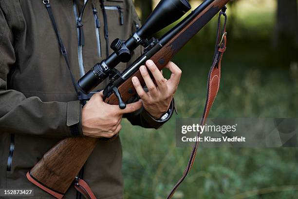 male hunter loading his rifle - rifle fotografías e imágenes de stock