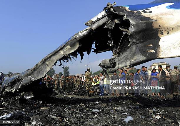 Nepalese rescue team members gather around at the remains of a Sita air plane after it crashed in Manohara, Bhaktapur on the outskirts of Kathmandu...