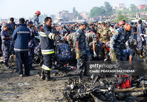 Nepalese rescue team members collect parts of wreckage at the remains of a Sita airplane after it crashed in Manohara, Bhaktapur on the outskirts of...