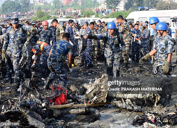 Nepalese rescue team members collect parts of wreckage at the remains of a Sita airplane after it crashed in Manohara, Bhaktapur on the outskirts of...
