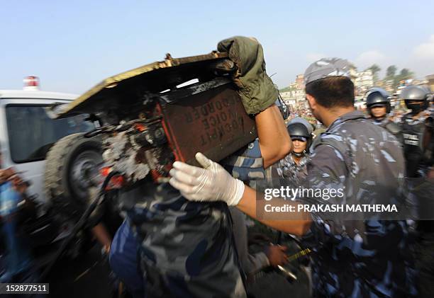 Nepalese police man carries the black box after it was recovered from a Sita airplane wreckage after it crashed in Manohara, Bhaktapur on the...