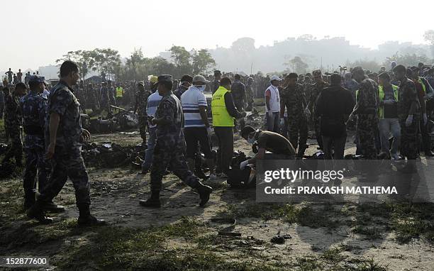Nepalese rescue team members look at human remains found in the wreckage of a Sita airplane after it crashed in Manohara, Bhaktapur on the outskirts...