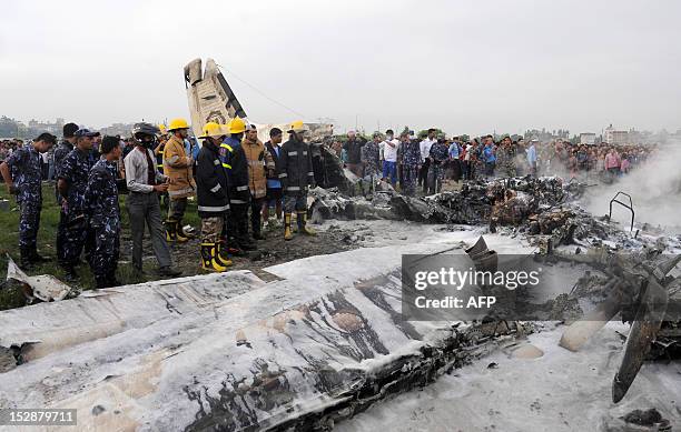 Nepalese fireman and volunteers look over the wreckage of a Sita airplane after it crashed in Manohara, Bhaktapur on the outskirts of Kathmandu on...