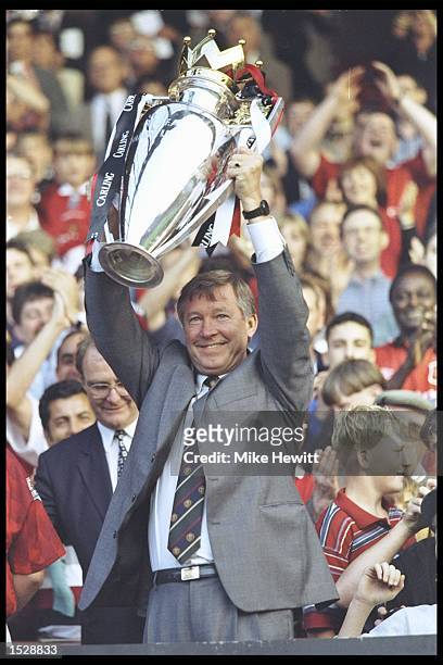 Alex Ferguson of Manchester United holds aloft the Premier league trophy before the start of the pre-season friendly between Manchester United and...