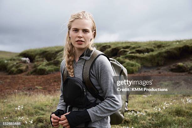 hiker carrying backpack on hillside - scandinavian woman blond stock pictures, royalty-free photos & images