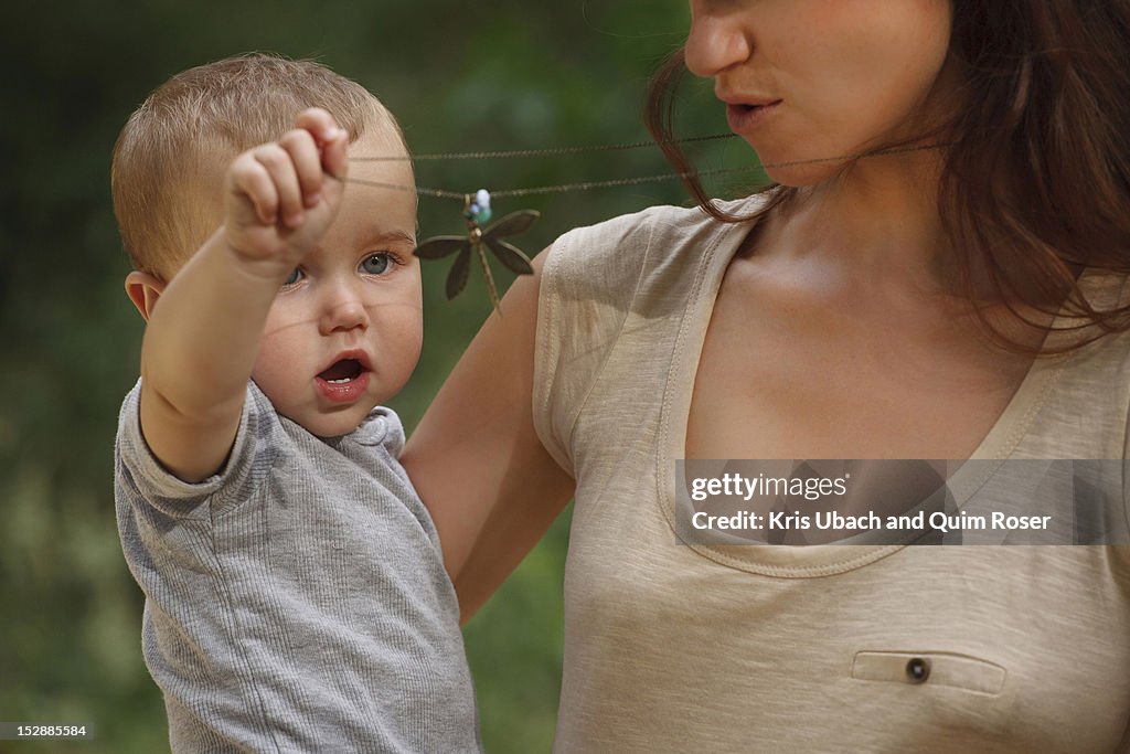 Toddler playing with mothers necklace