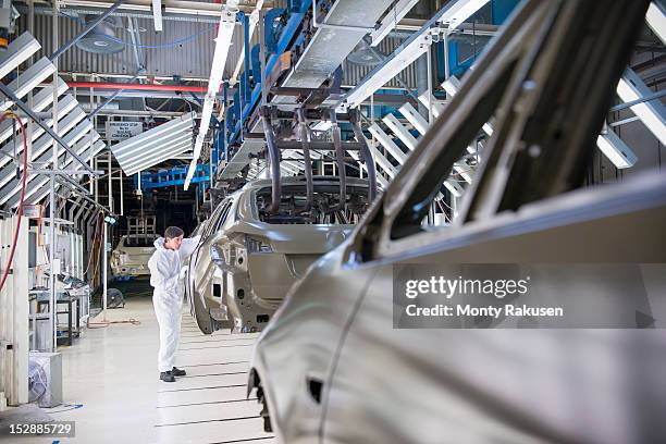 worker inspecting car body in car factory - clean suit fotografías e imágenes de stock