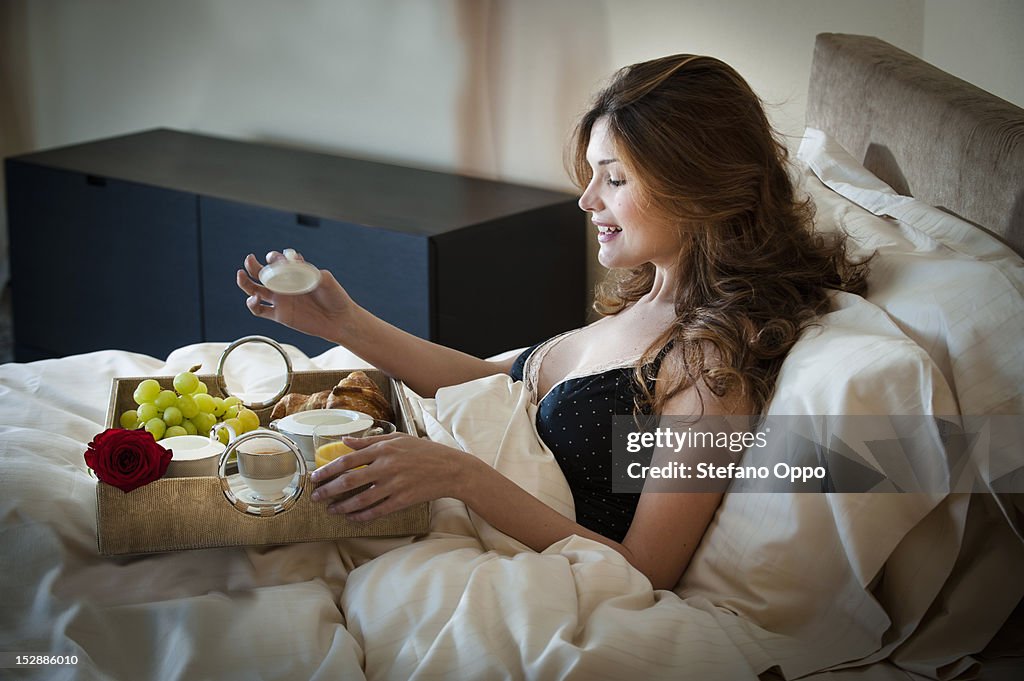 Woman eating breakfast in bed