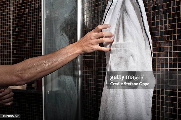 man reaching for bathrobe in shower - bathrobe stock pictures, royalty-free photos & images