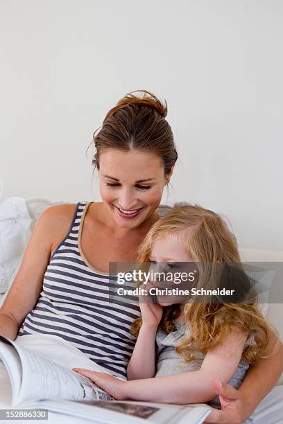 mother and daughter reading in bed - bedtime stock pictures, royalty-free photos & images