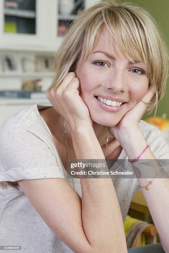Smiling woman resting chin in hands