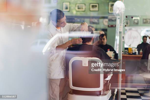 barber working on client in shop - barber shop interior stock pictures, royalty-free photos & images