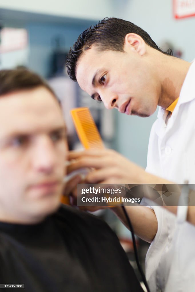 Barber working on client in shop