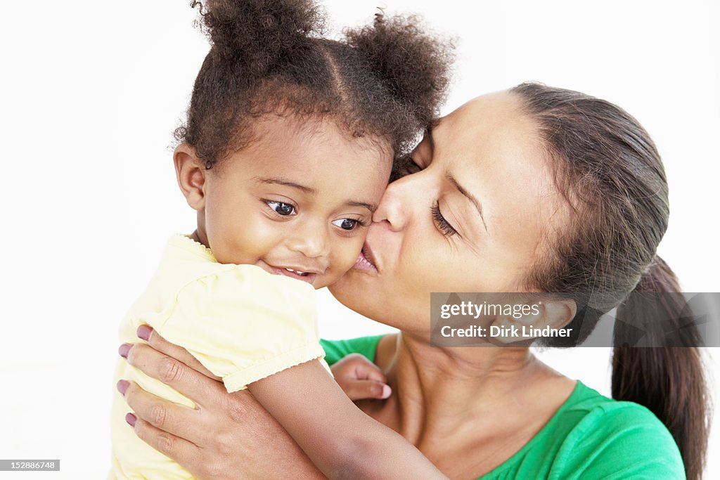 Mother and daughter kissing in kitchen