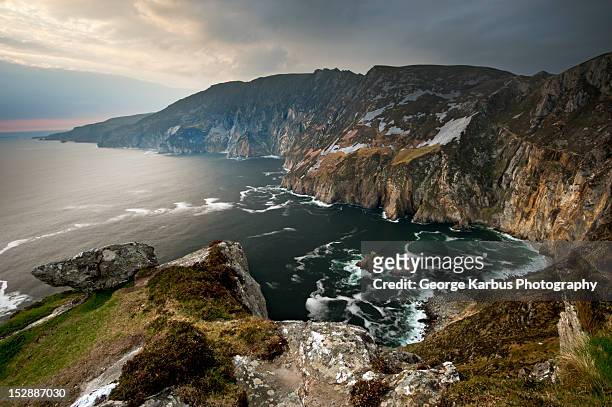 waves crashing on rocky cliffs - condado de donegal fotografías e imágenes de stock
