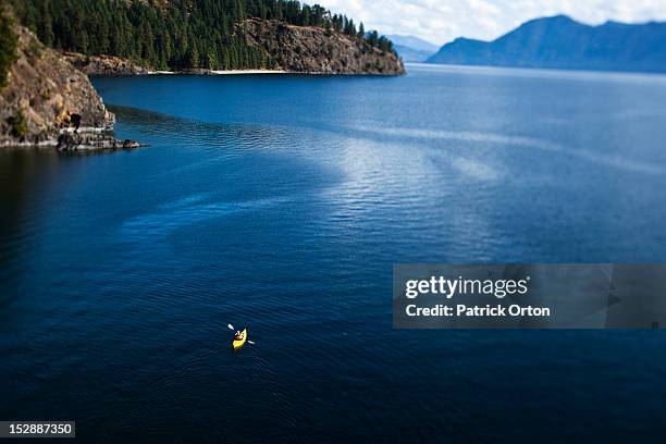 a athletic woman kayaking on a lake in idaho. - sandpoint stock pictures, royalty-free photos & images