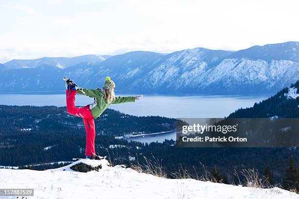 a beautiful young woman doing yoga while snowshoeing above a lake in idaho. - pend orielle lake stock pictures, royalty-free photos & images