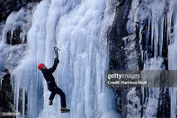 an ice climber boulders around at the ice at winding stair gap in hwy 64 near franklin, nc - ice climbing stock pictures, royalty-free photos & images