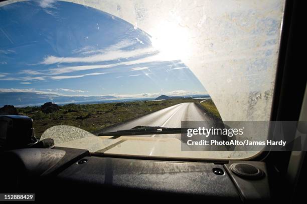 country road viewed through car windshield - ruitenwisser stockfoto's en -beelden