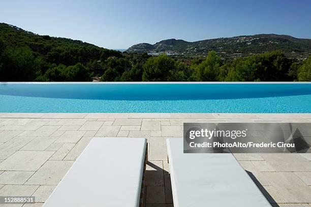 lounge chairs beside swimming pool - bordo piscina foto e immagini stock