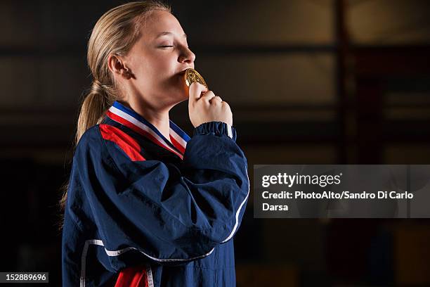 female athlete kissing gold medal - teen awards bildbanksfoton och bilder