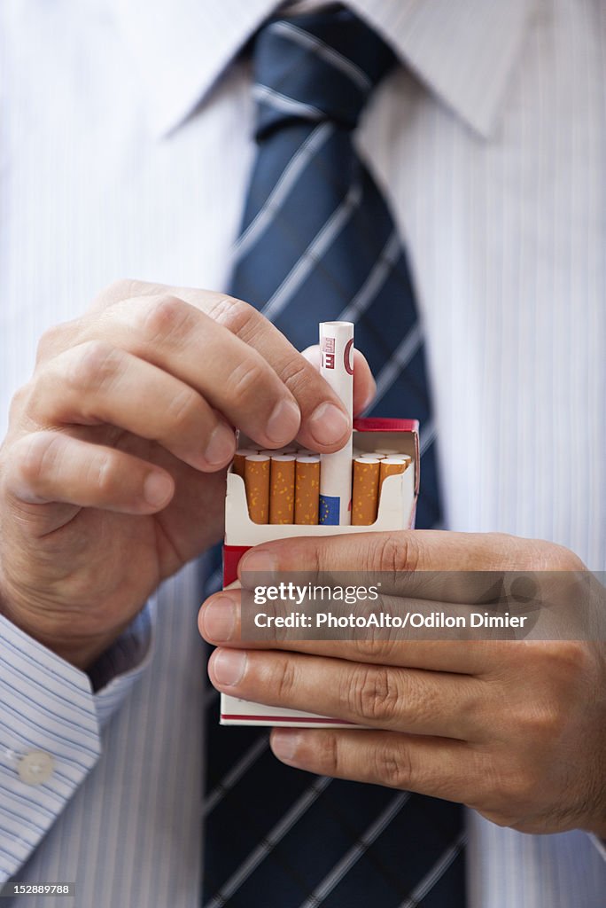 Removing rolled euro from cigarette pack
