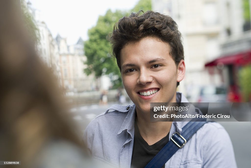 Young man outdoors, smiling