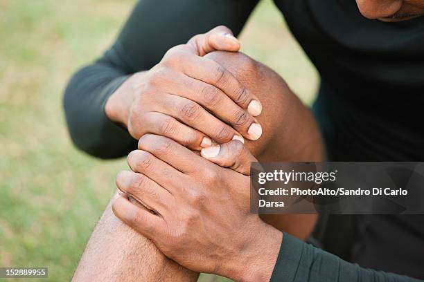 man holding injured knee, cropped - injured knee stock pictures, royalty-free photos & images