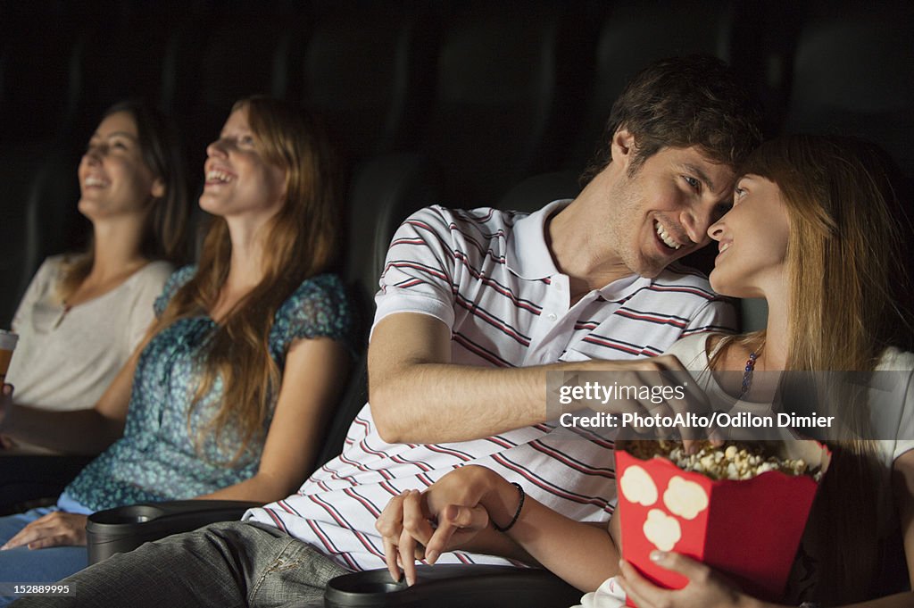 Couple looking at each other affectionately in movie theater