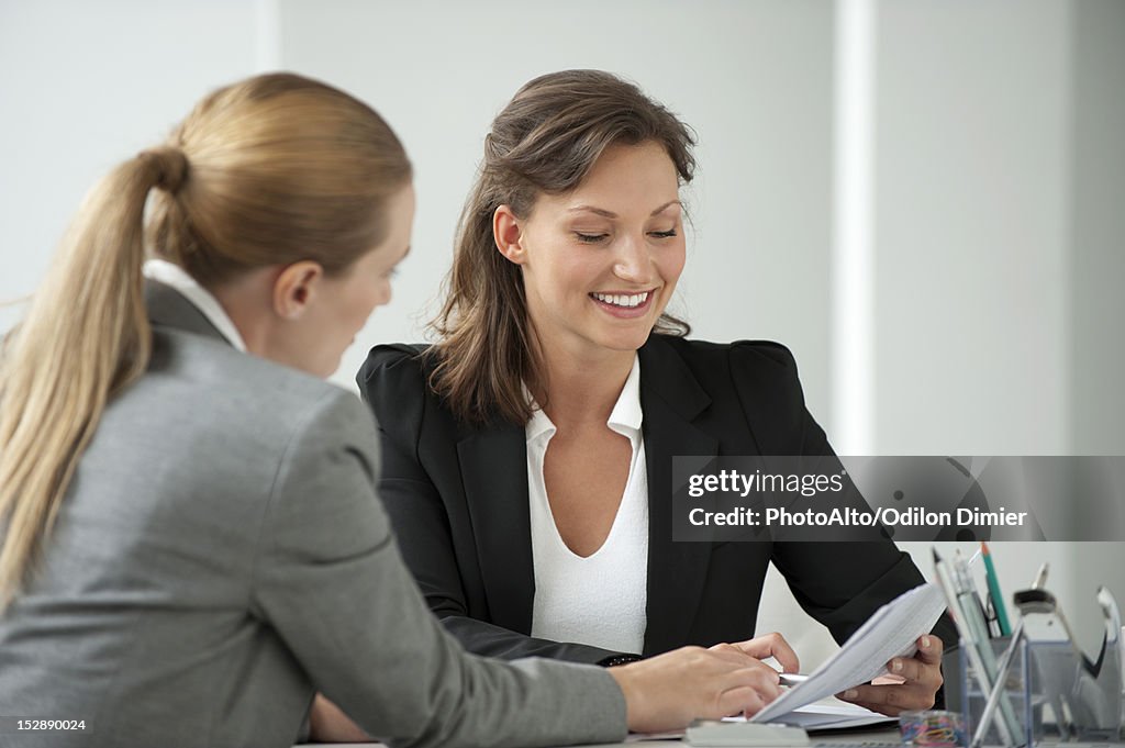 Businesswoman reviewing document with client