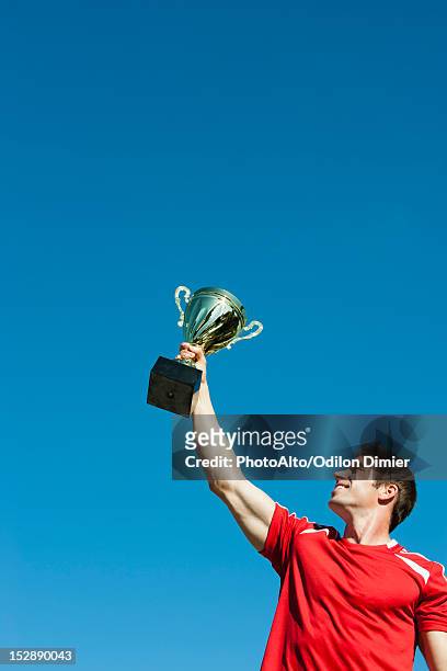 athlete holding up trophy - championship day one stock pictures, royalty-free photos & images