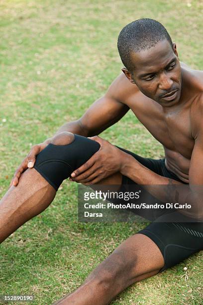 male athlete wearing knee brace - bent hand stock pictures, royalty-free photos & images