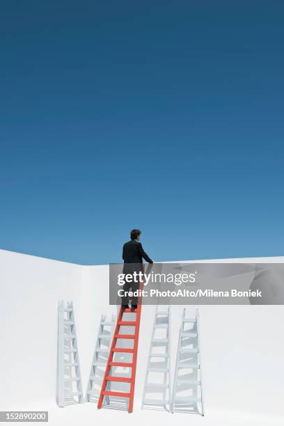 businessman climbing ladder, rear view - mirar por encima fotografías e imágenes de stock