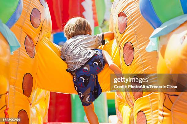 boy playing in bouncy castle, rear view - inflatable playground ストックフォトと画像