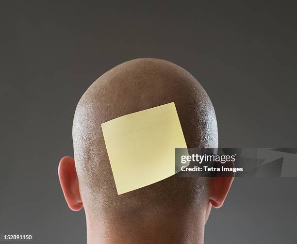 back view of man with adhesive note on shaved head - shaved head ストックフォトと画像