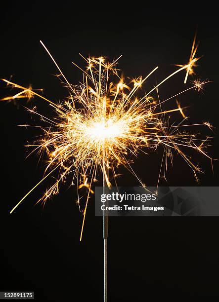 burning sparkler on black background - sparkler firework stock-fotos und bilder