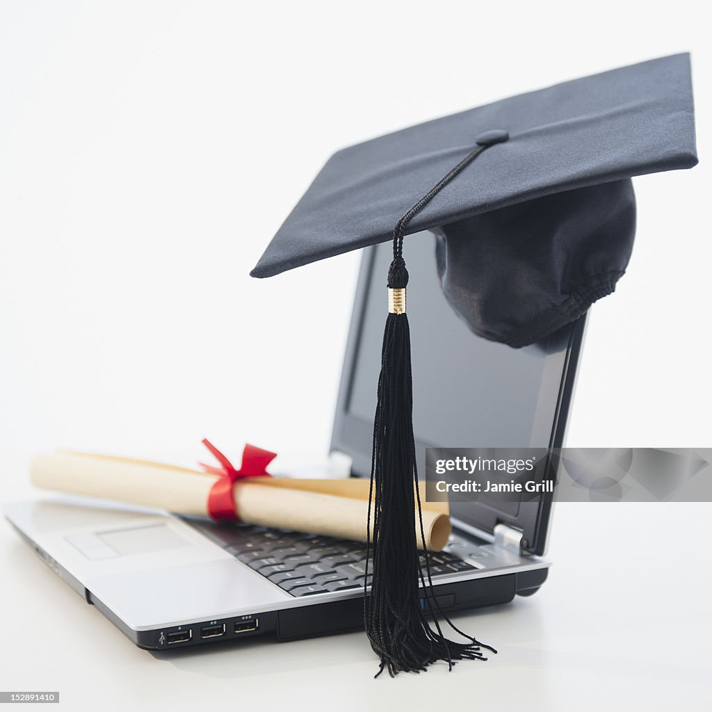 Laptop with diploma and mortar board