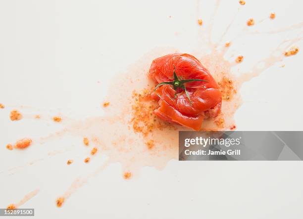 studio shot of smashed tomato - gooien stockfoto's en -beelden