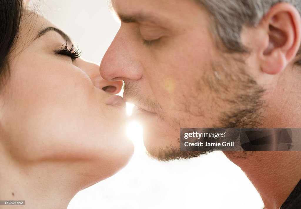 USA, New Jersey, Jersey City, Couple kissing in bright sunshine