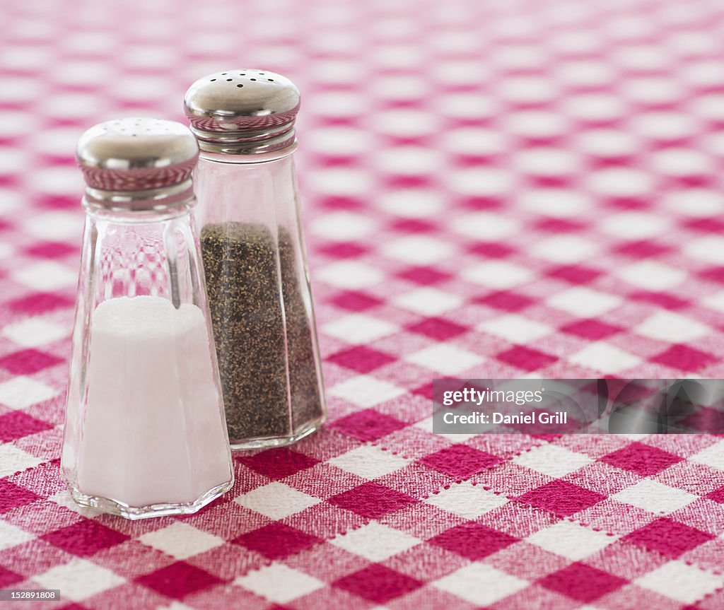 Salt and pepper shakers on checked tablecloth